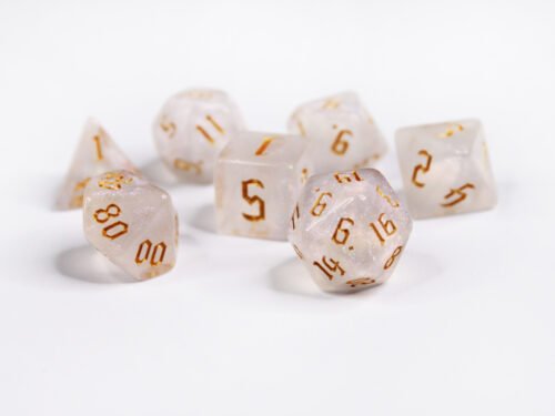 Collection of seven acrylic dice with fine glittery off-white colouring and gold numbers