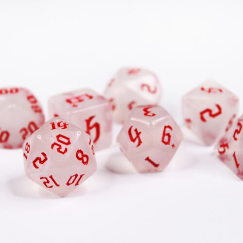 Collection of seven acrylic dice with fine glittery off-white colouring and red numbers