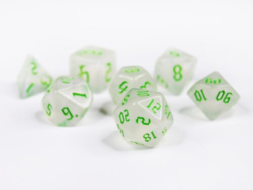 Collection of seven acrylic dice with fine glittery off-white colouring and green numbers