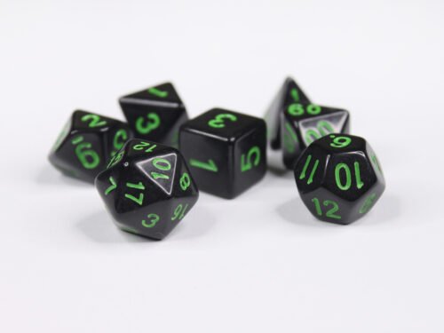 Collection of seven acrylic dice with plain black colouring and green numbers