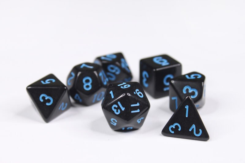 Collection of seven acrylic dice with plain black colouring and blue numbers