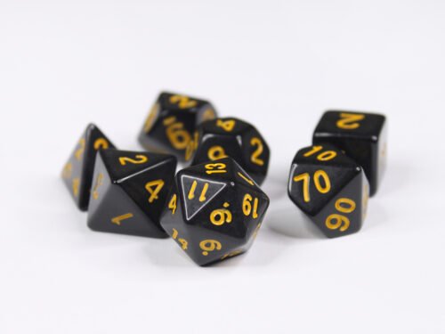 Collection of seven acrylic dice with plain black colouring and yellow numbers