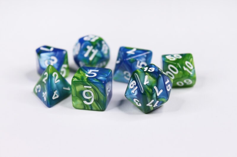 Collection of seven acrylic dice with swirled pearly blue and green colouring and white numbers