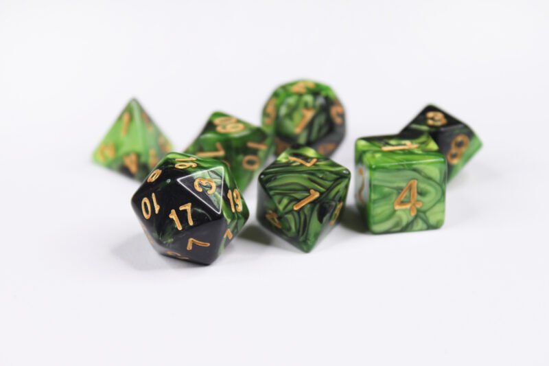 Collection of seven acrylic dice with swirled pearly black and green colouring and gold numbers