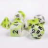 Collection of seven acrylic dice with swirled white and light acid green colouring and black numbers