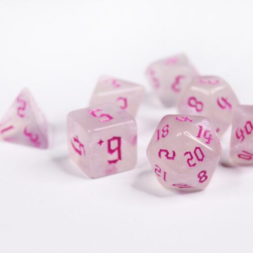Collection of seven acrylic dice with fine glittery off-white colouring and pink numbers