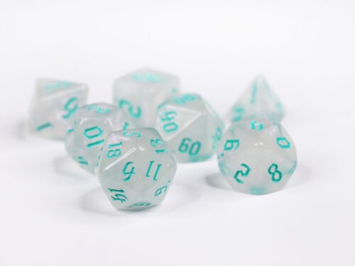 Collection of seven acrylic dice with fine glittery off-white colouring and sea foam blue numbers