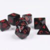 Collection of seven acrylic dice with plain black colouring and red numbers