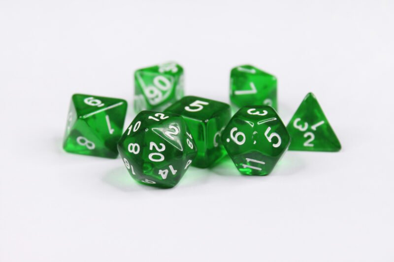 Collection of seven acrylic dice with clear forest green colouring and white numbers
