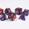 Collection of seven acrylic dice with swirled fine glittery pink and blue colouring and gold numbers