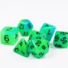 Collection of seven glow-in-the-dark acrylic dice with swirled green and blue colouring and black numbers