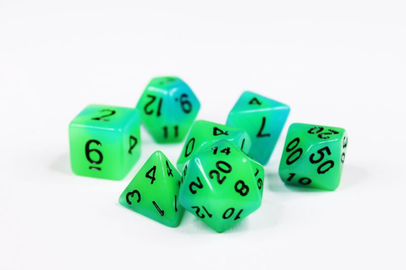 Collection of seven glow-in-the-dark acrylic dice with swirled green and blue colouring and black numbers