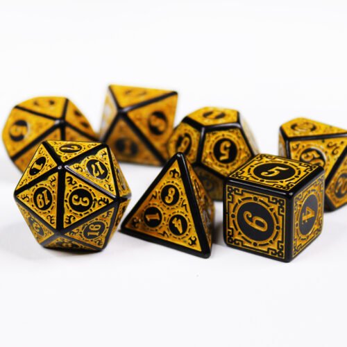 Collection of seven black dice with embossed swirling patterns and yellow coloured motif and numbering