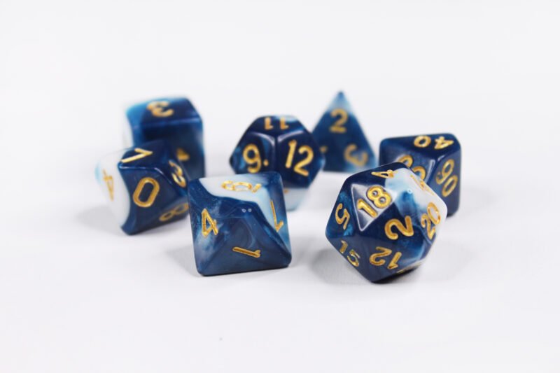 Collection of seven acrylic dice with swirled white and dark blue colouring and gold numbers