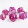 Collection of seven acrylic dice with swirled fine glittery pink and white colouring and gold numbers