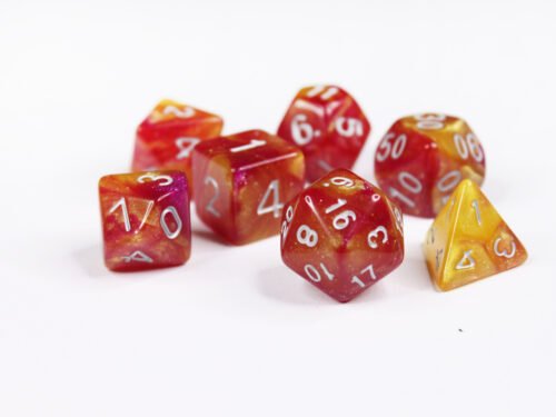 Collection of seven acrylic dice with swirled fine glittery yellow and red colouring and white numbers