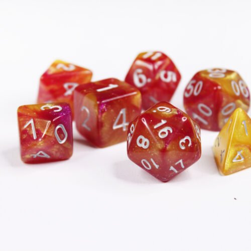 Collection of seven acrylic dice with swirled fine glittery yellow and red colouring and white numbers