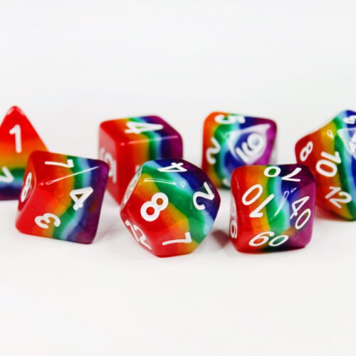 Collection of seven acrylic dice with rows of colour like a rainbow and white numbers