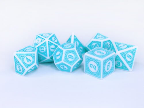 Collection of seven white dice with embossed swirling patterns and turquoise coloured motif and numbering