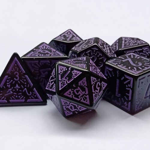 Collection of seven black dice with embossed moon and star patterns and purple coloured motif and numbering