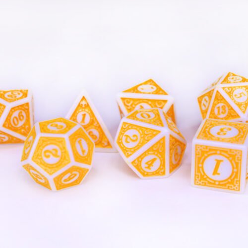 Collection of seven white dice with embossed swirling patterns and yellow coloured motif and numbering