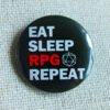 A black button badge showing the text Eat Sleep RPG Repeat and a D20 outline. The word RPG is in red, the rest is in white.