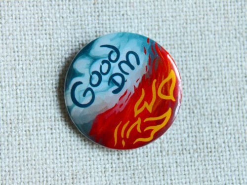 An illustrated button badge with one half that shows blue sky and clouds and text that reads Good DM and another half that shows flames and the text Evil DM.