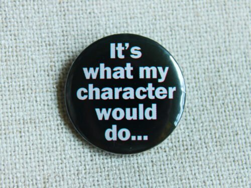 A black coloured button badge which reads the text "It's what my character would do..." in white lettering.