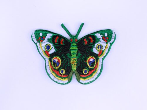 An embroidered patch of a green butterfly with white black blue red and yellow markings.