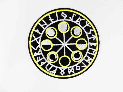 A circular embroidered patch of a the eight moon cycles encircled by Norse runes in black white and yellow.
