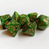 Collection of seven green dice with embossed dragon patterns and gold coloured motif and numbering.