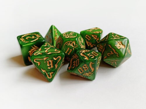 Collection of seven green dice with embossed dragon patterns and gold coloured motif and numbering.