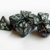 Collection of seven dark grey dice with embossed dragon patterns and white coloured motif and numbering.